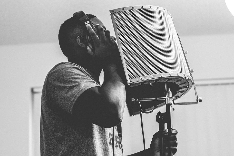 Vocalist recording at a studio microphone and pop screen